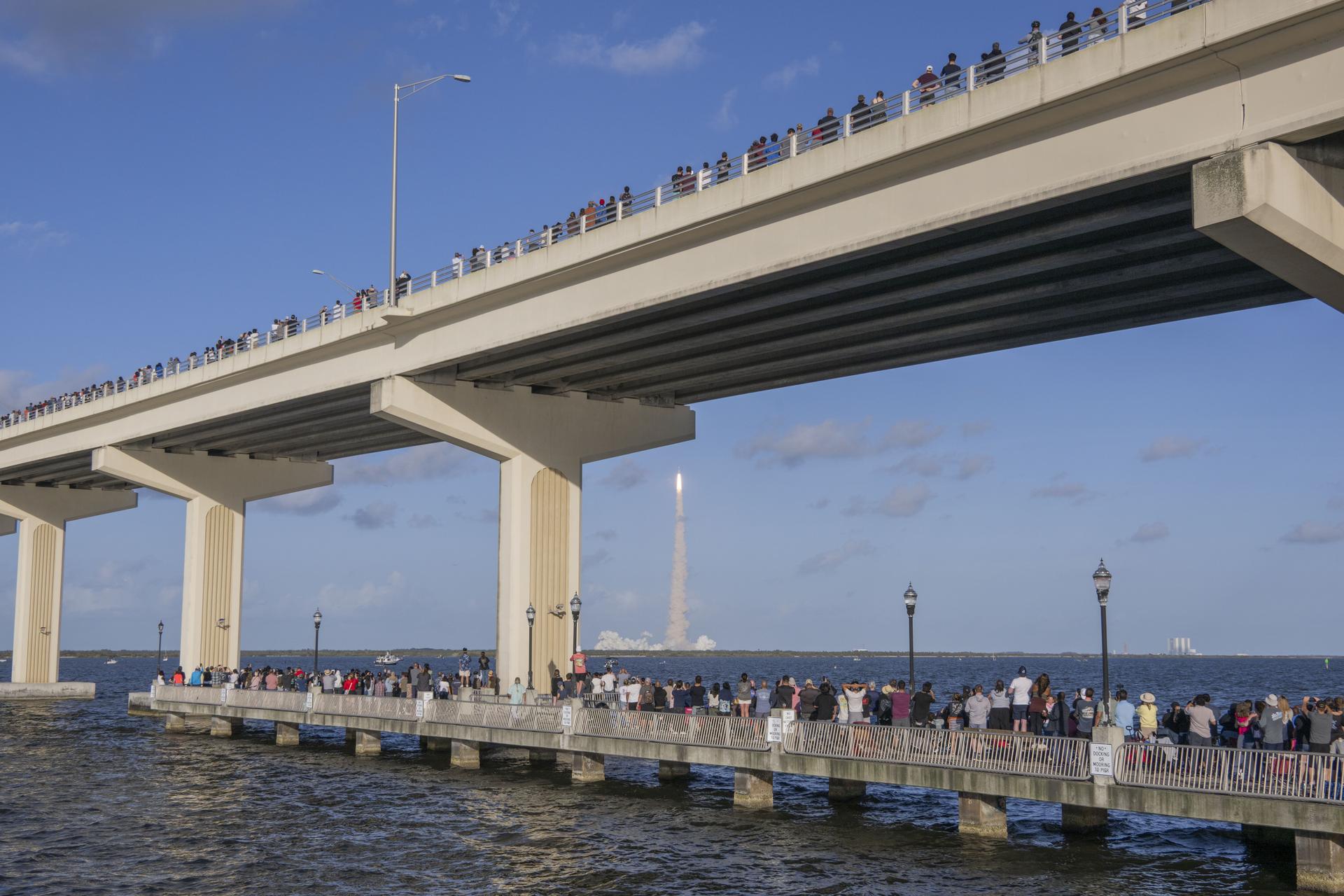 Crowds gather at the Max A. Brewer Bridge in Titusville to watch the launch of NASA’s SLS (Space Launch System) rocket with the Orion spacecraft carrying Artemis II Commander Reid Wiseman, Pilot Victor Glover, and Mission Specialist Christina Koch from NASA, along with Mission Specialist Jeremy Hansen from the CSA (Canadian Space Agency), on Wednesday, April 1, 2026, from Launch Complex 39B at NASA Kennedy. The Artemis II test flight will take the crew members on a 10-day journey around the Moon and back.  