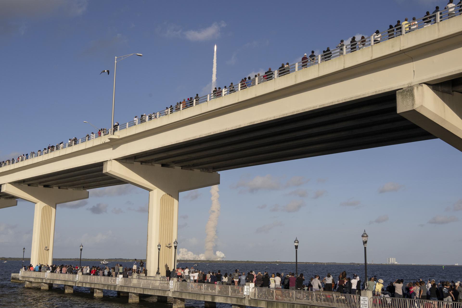Crowds gather at the Max A. Brewer Bridge in Titusville to watch the launch of NASA’s SLS (Space Launch System) rocket with the Orion spacecraft carrying Artemis II Commander Reid Wiseman, Pilot Victor Glover, and Mission Specialist Christina Koch from NASA, along with Mission Specialist Jeremy Hansen from the CSA (Canadian Space Agency), on Wednesday, April 1, 2026, from Launch Complex 39B at NASA Kennedy. The Artemis II test flight will take the crew members on a 10-day journey around the Moon and back.