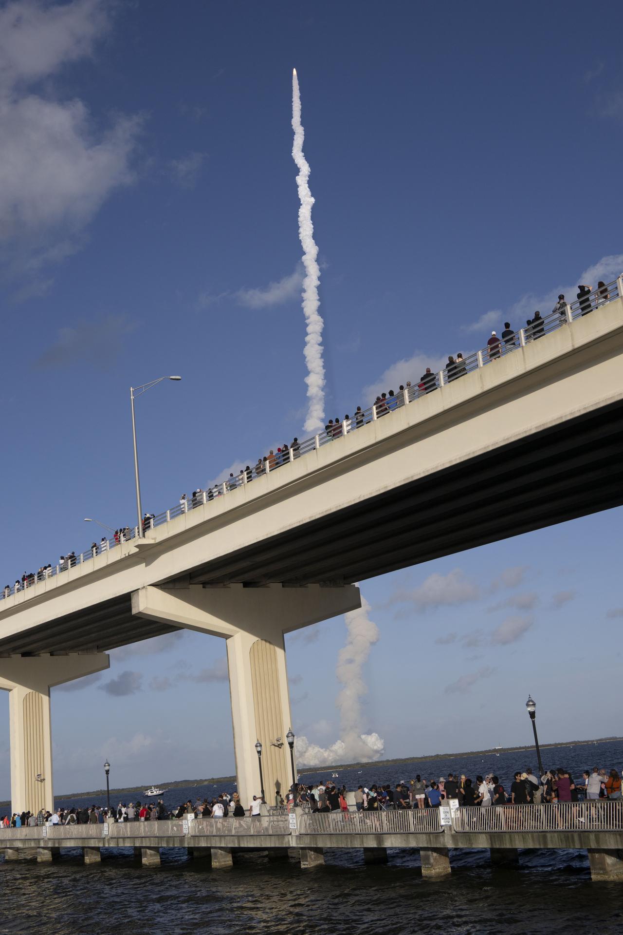 Crowds gather at the Max A. Brewer Bridge in Titusville to watch the launch of NASA’s SLS (Space Launch System) rocket with the Orion spacecraft carrying Artemis II Commander Reid Wiseman, Pilot Victor Glover, and Mission Specialist Christina Koch from NASA, along with Mission Specialist Jeremy Hansen from the CSA (Canadian Space Agency), on Wednesday, April 1, 2026, from Launch Complex 39B at NASA Kennedy. The Artemis II test flight will take the crew members on a 10-day journey around the Moon and back.  