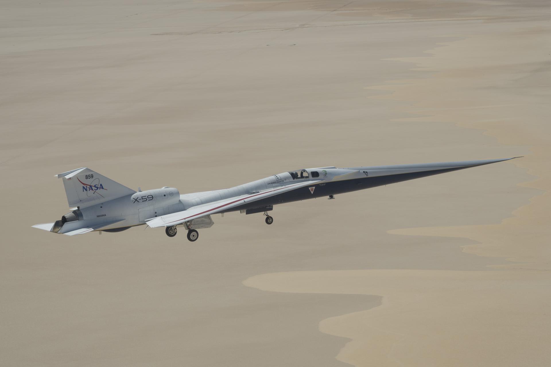 NASA’s X-59 quiet supersonic research aircraft flies over Rogers Dry Lake near NASA’s Armstrong Flight Research Center in Edwards, California, on Tuesday, May 12, 2026. NASA continues expanding the aircraft’s flight envelope through a series of lower-altitude and slower-speed flights ahead of flight tests at speeds faster than the speed of sound.