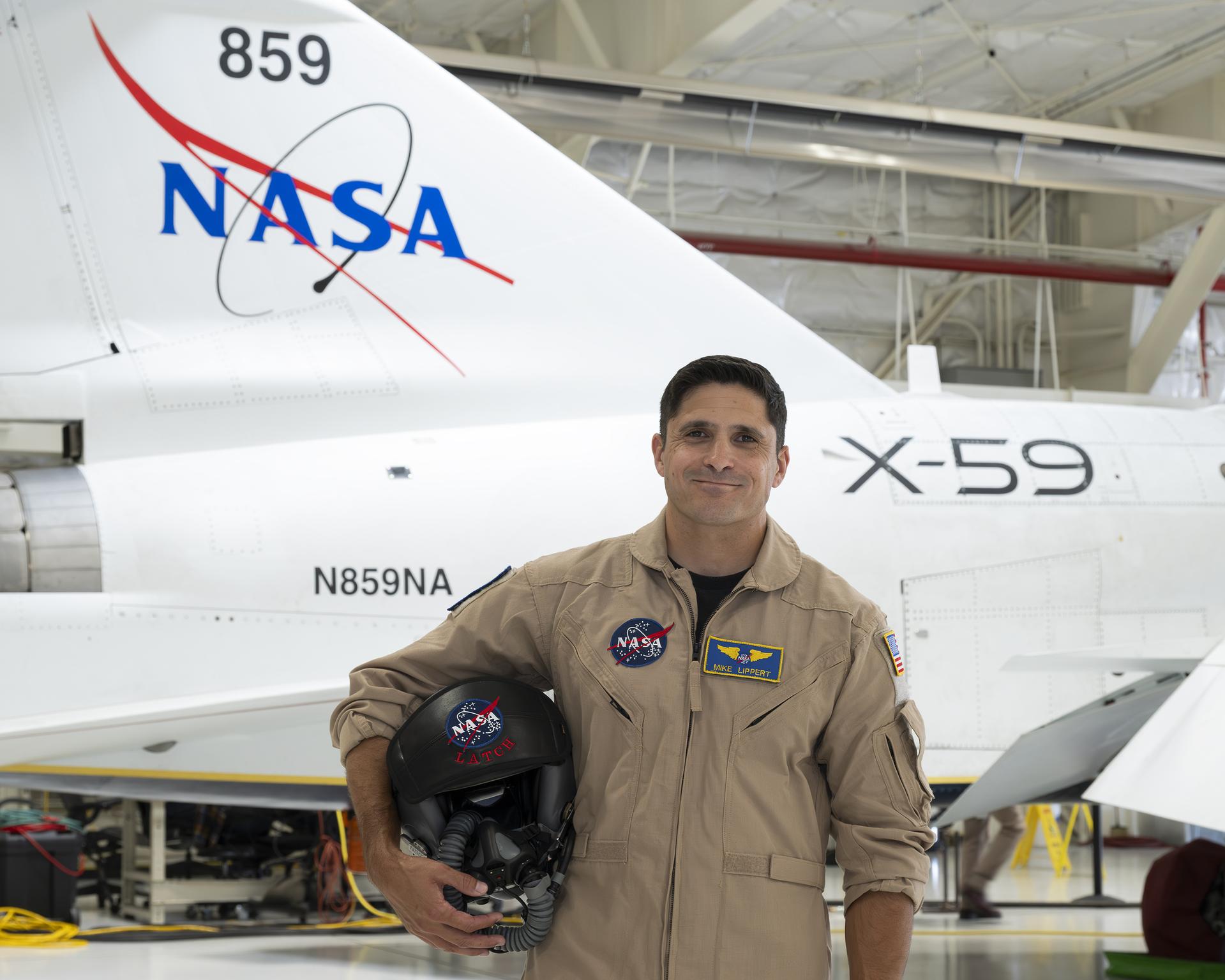 NASA’s X-59 test pilot Mike Lippert stands in front of the agency's X-59 quiet supersonic research aircraft at NASA's Armstrong Flight Research Center in Edwards, California, on Wednesday, June 24, 2026. Lippert joins NASA as the third X-59 pilot supporting the Quesst mission, which will eventually fly over U.S. communities to demonstrate quiet supersonic flight and collect feedback from the public about the aircraft’s quiet sonic “thump.”