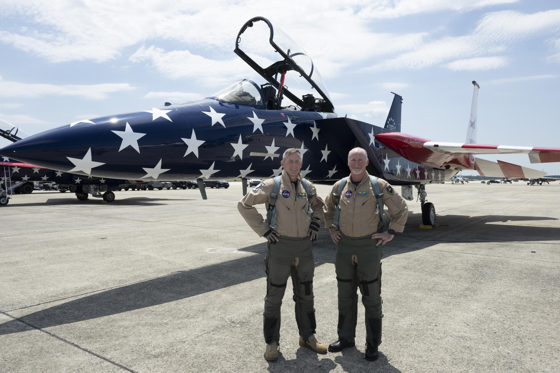 NASA Armstrong pilot Jim Less, left, and center director, Troy Asher, right, stand in front of a NASA F-15 aircraft on Saturday, July 4, 2026. Both pilots took part in a flyover to celebrate America’s 250th birthday. This aircraft is from NASA’s Armstrong Flight Research Center in Edwards, California, and it joined other NASA aircraft for the flyover.
