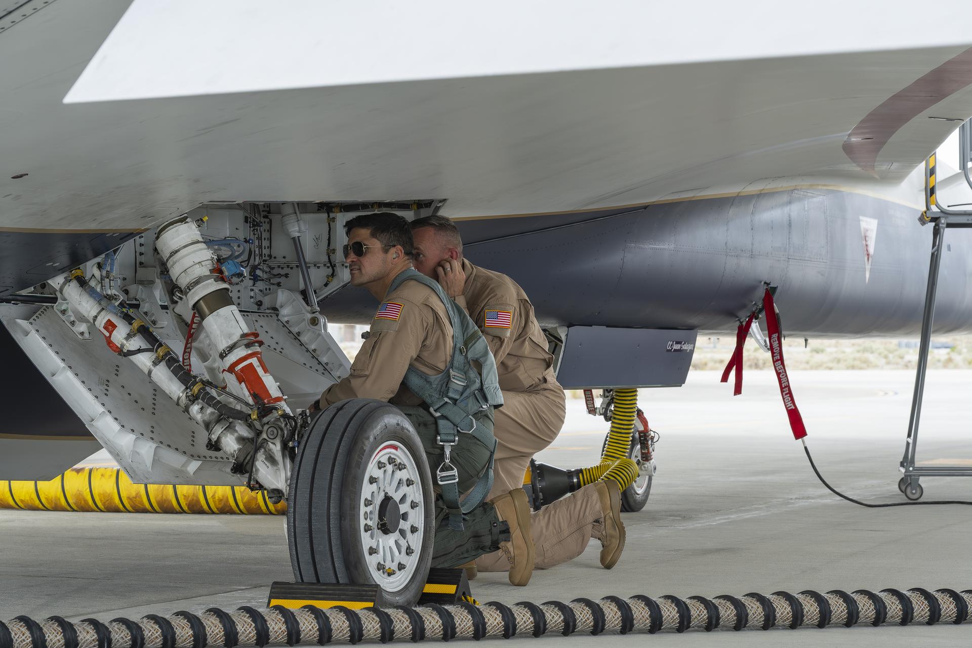 NASA X‑59 test pilots Mike Lippert, left, and Jim “Clue” Less inspect the wheel compartment before an engine run of the agency’s X‑59 quiet supersonic research aircraft at NASA’s Armstrong Flight Research Center in Edwards, California, on Thursday, Aug. 27, 2026. The test marked the first time Lippert operated the aircraft and became familiar with its cockpit. NASA’s Quesst mission will demonstrate quiet supersonic flight over U.S. communities and gather public feedback on the aircraft’s quieter sonic “thump.”