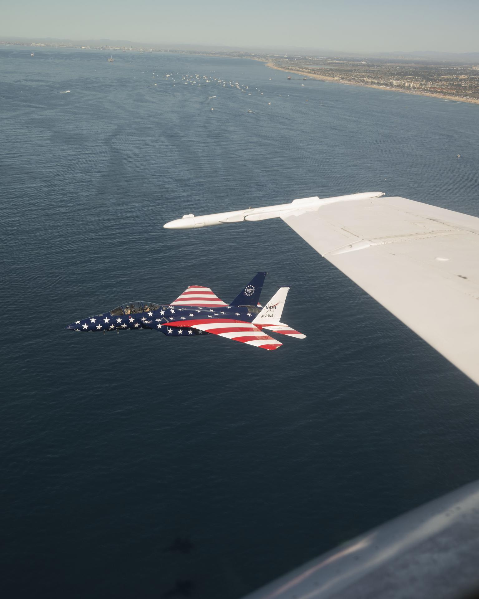 A NASA F‑15 aircraft is shown flying next to a NASA F/A‑18 during the Pacific Airshow in Huntington Beach, California, Saturday, Oct. 3, 2026. The F‑15, from NASA’s Armstrong Flight Research Center in Edwards, California, is painted in honor of America’s 250th birthday.