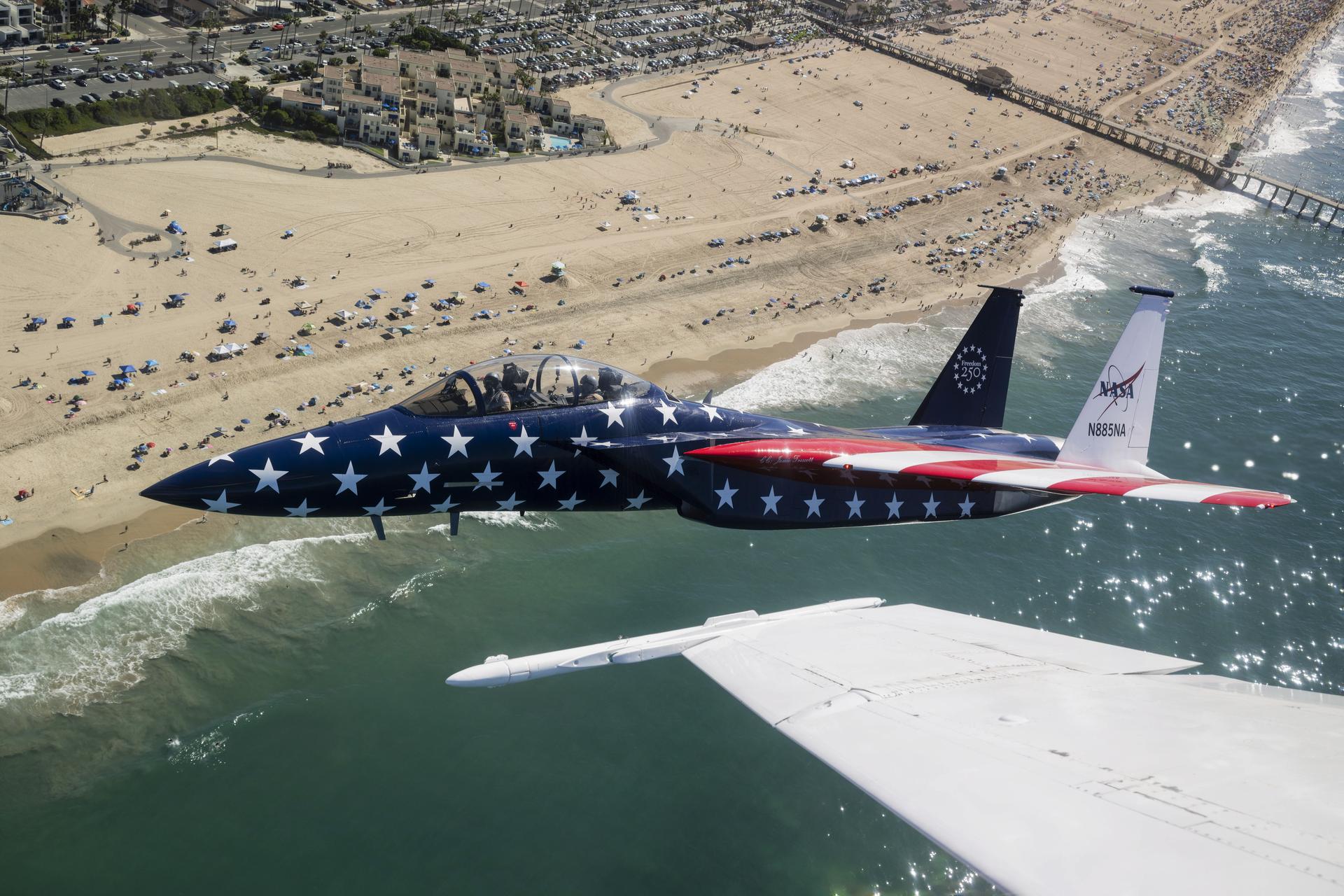 A NASA F‑15 aircraft is shown flying next to a NASA F/A‑18 during the Pacific Airshow in Huntington Beach, California, Saturday, Oct. 3, 2026. The F‑15, from NASA’s Armstrong Flight Research Center in Edwards, California, is painted in honor of America’s 250th birthday.