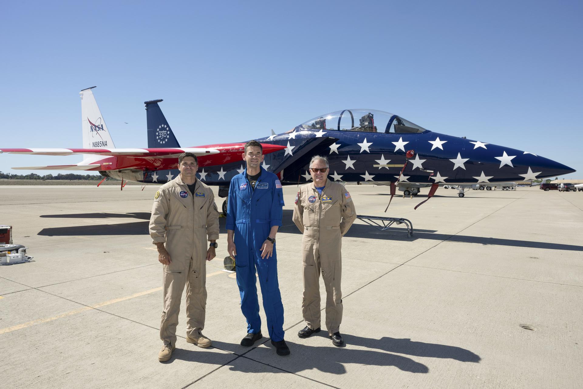NASA’s 15th Administrator Jared Issacman, center, poses for a photo with NASA pilots Mike Lippert, left, and Wayne Ringelberg in front of agency’s newly painted F‑15, which honors America’s 250th birthday, during the Pacific Airshow in Huntington Beach, California, Saturday, Oct. 3, 2026.