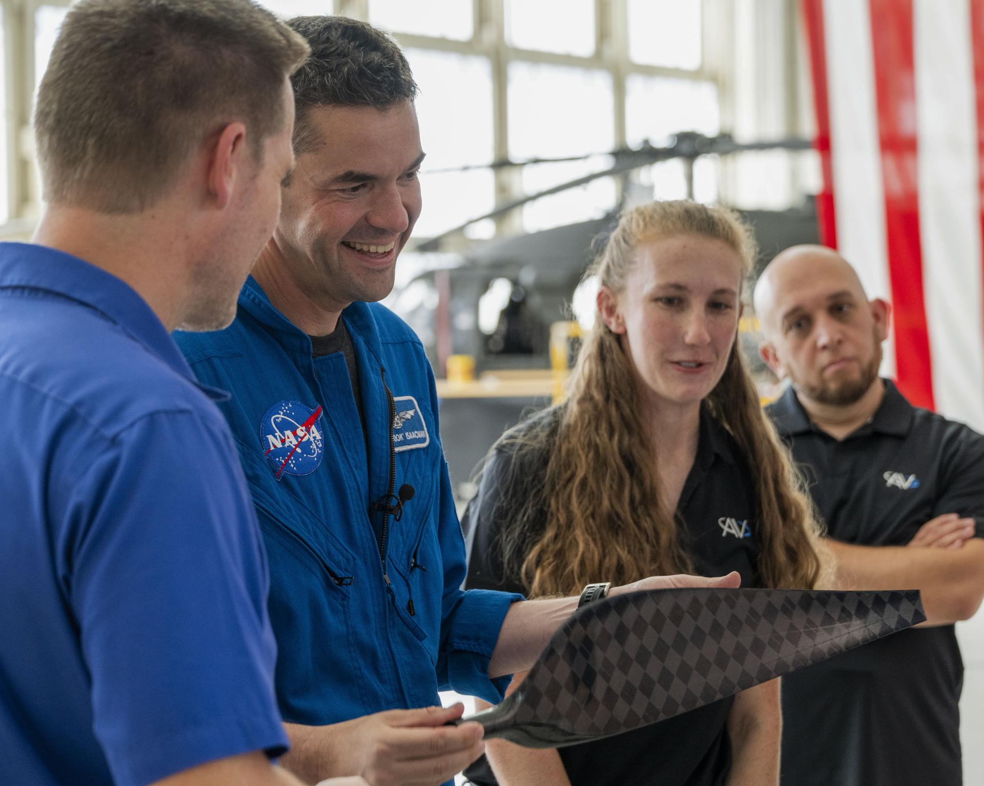 NASA’s 15th Administrator Jared Issacman, second from left, holds a SkyFall propeller bladeduring Jet Propulsion Laboratory’s demonstration of the next evolution of Mars helicopters at Los Alamitos Joint Forces Training Base, California, Saturday, Oct. 3, 2026. Also pictured are, from left, JPL SkyFall project manager Håvard Grip and AeroVironment team members Paulina Ridland and Steve Quintero.