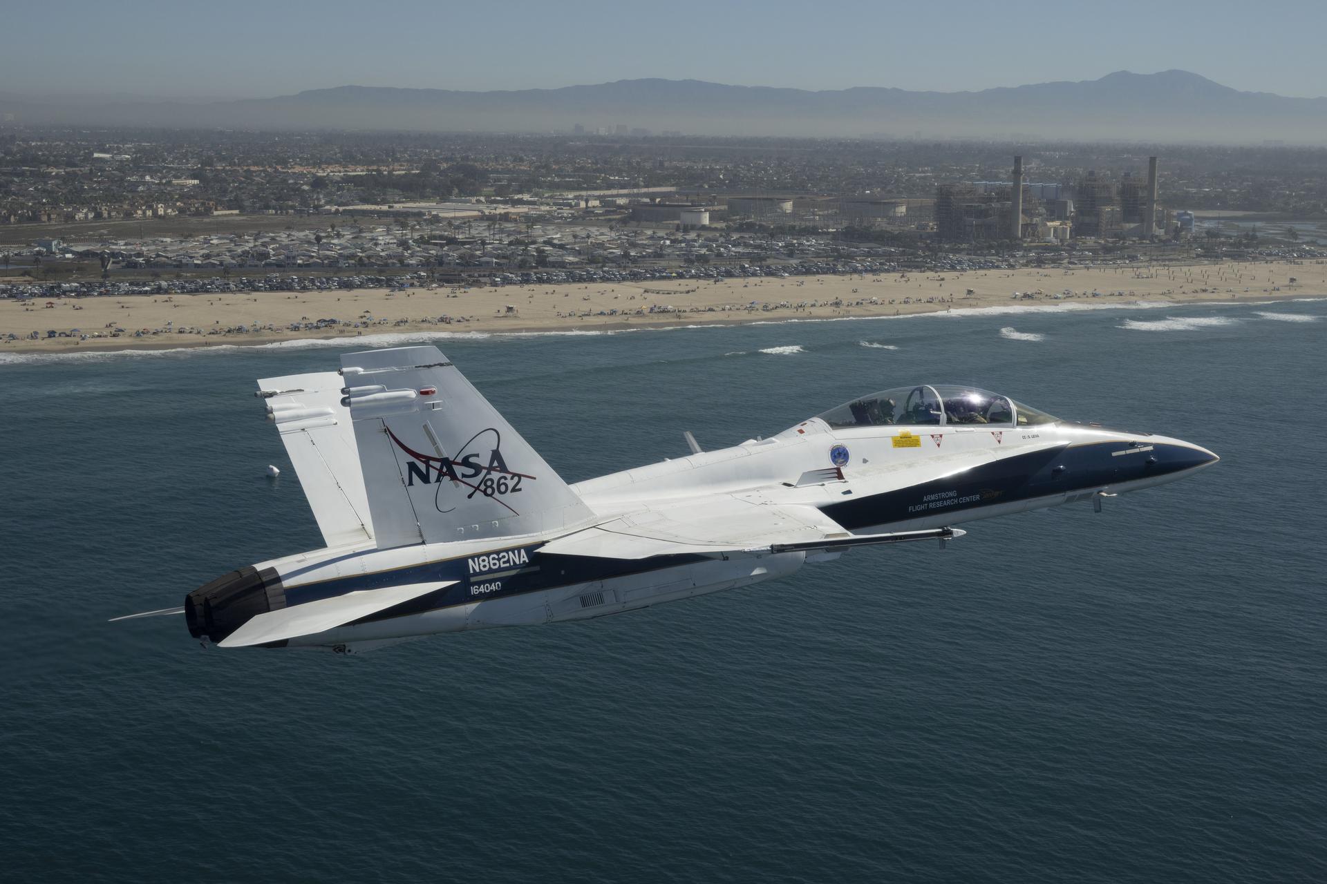 NASA test pilot Mike Lippert flies an F/A‑18 with videographer Lori Losey in the back seat during a Pacific Airshow flyover at Huntington Beach, California, Friday, Oct. 2, 2026. NASA is also hosting an exhibit featuring Artemis, the X‑59, SkyFall, a lunar globe, and an Apollo 15 Moon rock, with pilots and research experts available throughout the weekend.