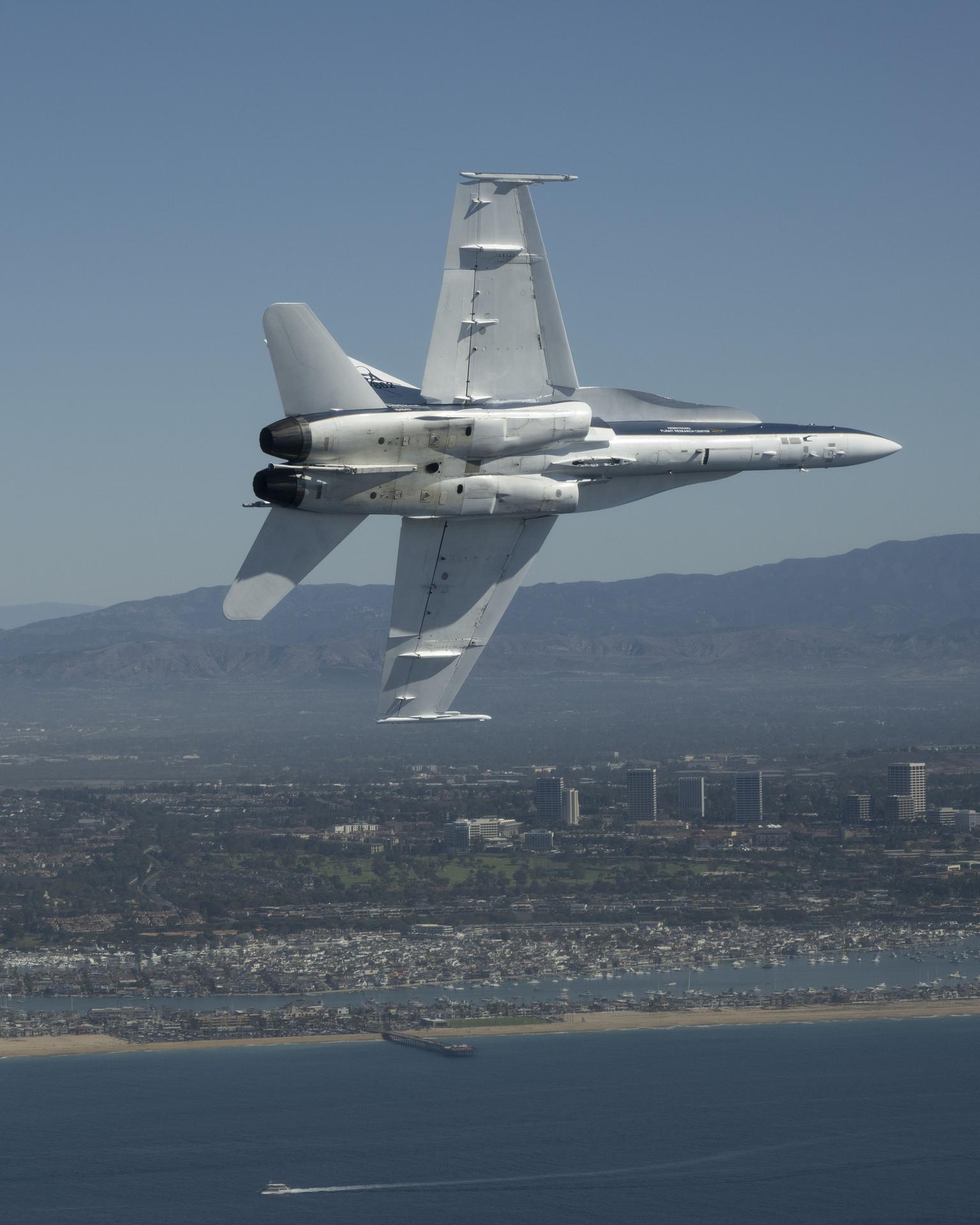 NASA test pilot Mike Lippert flies an F/A‑18 with videographer Lori Losey in the back seat during a Pacific Airshow flyover at Huntington Beach, California, Friday, Oct. 2, 2026. NASA is also hosting an exhibit featuring Artemis, the X‑59, SkyFall, a lunar globe, and an Apollo 15 Moon rock, with pilots and research experts available throughout the weekend.