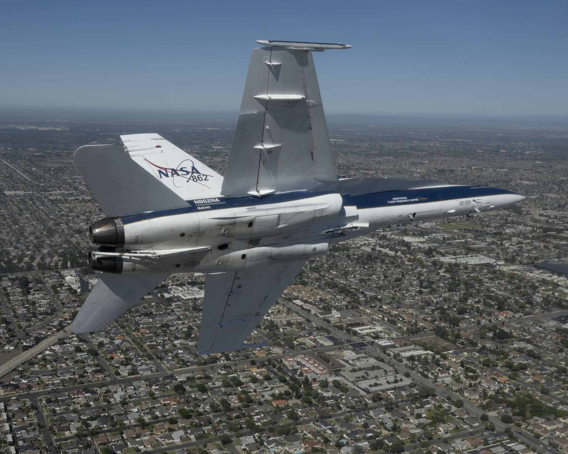 NASA test pilot Mike Lippert flies an F/A‑18 with videographer Lori Losey in the back seat during a Pacific Airshow flyover at Huntington Beach, California, Friday, Oct. 2, 2026. NASA is also hosting an exhibit featuring Artemis, the X‑59, SkyFall, a lunar globe, and an Apollo 15 Moon rock, with pilots and research experts available throughout the weekend.