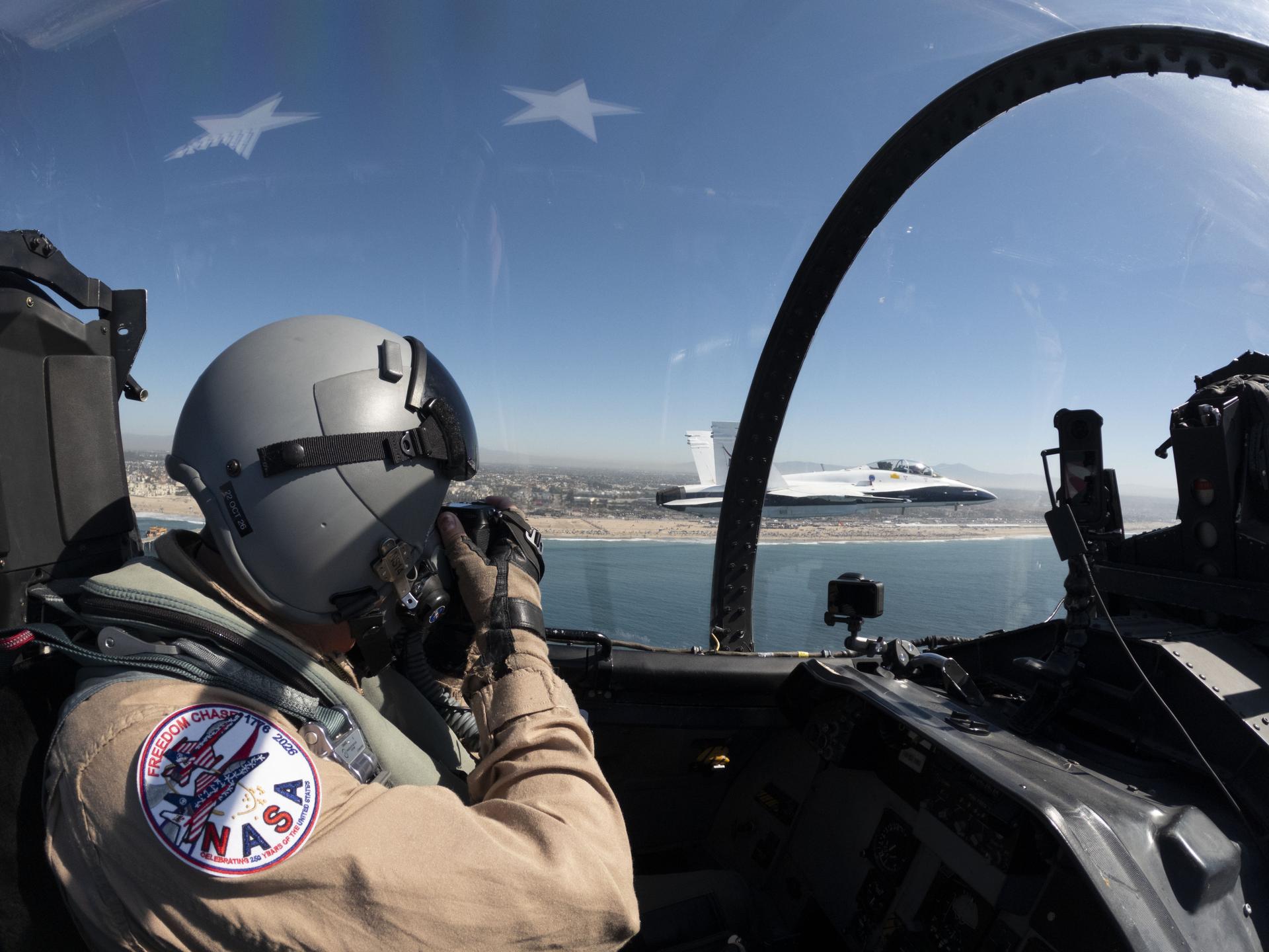 Photographer Jim Ross captures images of NASA’s F/A‑18 from the back seat of an F‑15 flying alongside during the Pacific Airshow at Huntington Beach, California, Friday, Oct. 2, 2026. NASA is also hosting an exhibit featuring Artemis, the X‑59, SkyFall, a lunar globe, and an Apollo 15 Moon rock.
