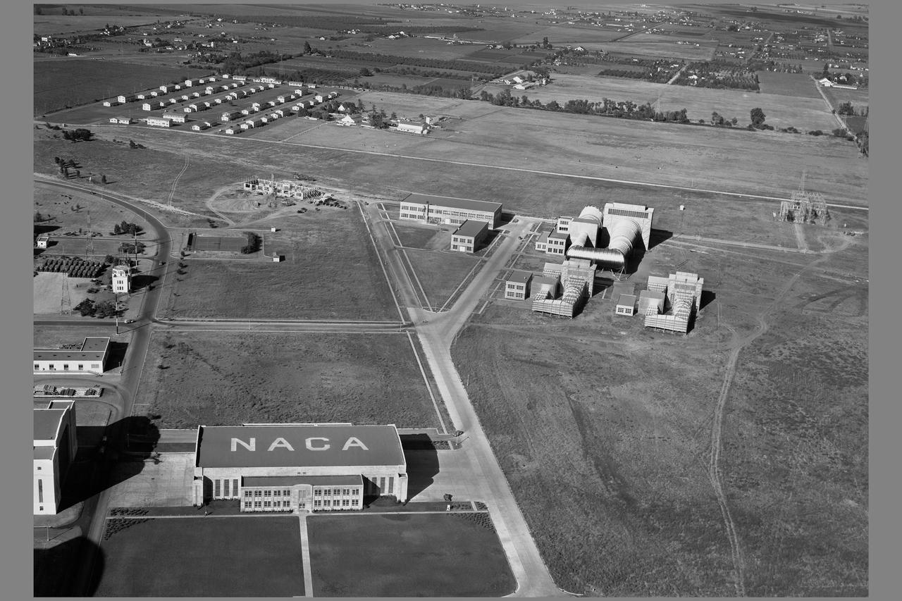 Ames Aeronautical Research Laboratory aerial shows original flight research hangar in foreground,  the two 7x10ft w.t. the 16ft w.t. and Admin buildings   NOTE: printed in  NASA Ames Publications: Adventures in Research - SP-4320; Searching the Horizon - SP 4304; 57 Years - Flight Research at AMES - NASA SP-1998-3300