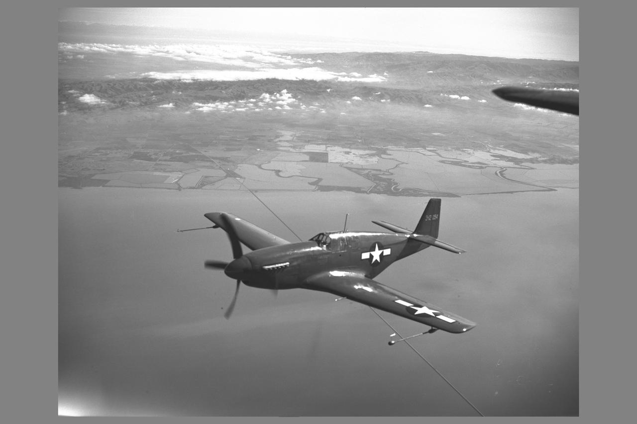 North American P-51B 'Mustang' fighter in flight over bay area. The P-51 with its new laminar-flow wing sections developed by NACA was the first airplane selected for testing of airplane drag in flight and wind tunnel comparison  NOTE: used in NASA Publication; Flight Research at Ames: 57 Years of Development and Validation of Aeronautical Technology' Transonic Model Testing fig. 9 NASA SP-1998-3300