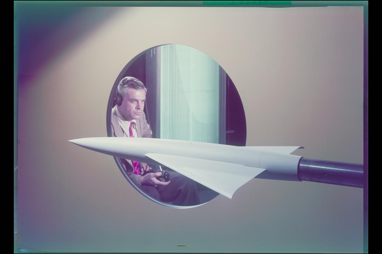 Charles Hall displaying tunnel model AR-2 which incorporates conical camber as the half-cone twist in the wings (in simulated 2x4' tunnel) Note: printed in 60 year at NASA Ames Research Center by Glenn Bugos NASA SP-2000-4314