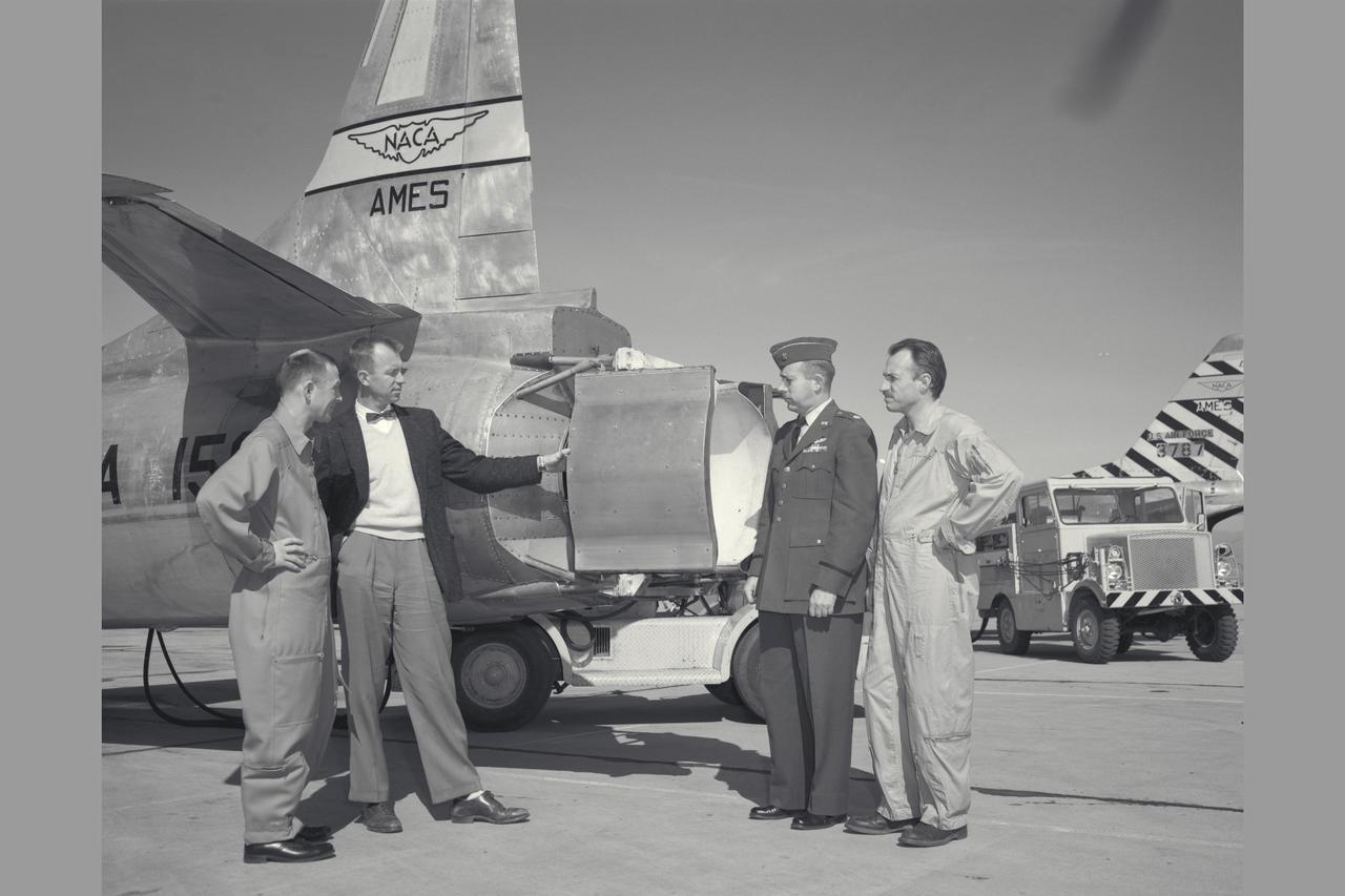 NACA Photographer Thrust reverser on F-94C-1 (AF50-956 NACA 156) Starfire (l to R) Air Force Major E. Sommerich; Ames Engineer Seth Anderson,  Lt. Col. Tavasti; and Ames Chief test pilot George Cooper discussing phases of flight evaluation tests. Note:  Used in publication in Flight Research at Ames;  57 Years of Development and Validation of Aeronautical Technology NASA SP-1998-3300 fig 91