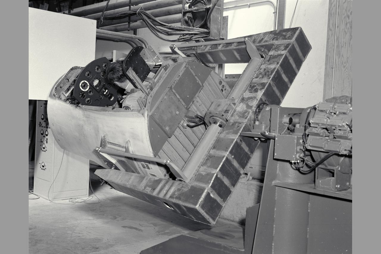 3/4 rear view with pilot Merriweather - 60 degrees bank angle. NE-2 degree of freedom simulator set-up for pitch and roll motion.