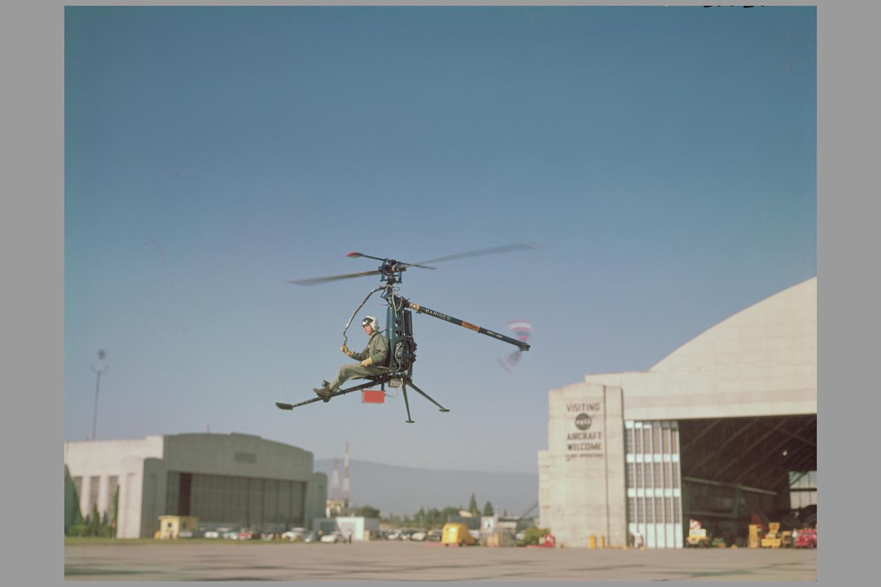 Ames aerodynamicists tested a wide variety of VTOL aircraft and helicopters during the 1960's. Here the Hiller rotorcycle YROE-1, made by Hiller Helicopter in nearby PaloAlto, California, hovers in front of the Ames Hangar. (4020, 4021, 4024)  Published in  NASA SP Flight Research at Ames: 57 Years of Development and Validation of Aeronautical Technology and Ames 60yr History Atmosphere of Freedom.