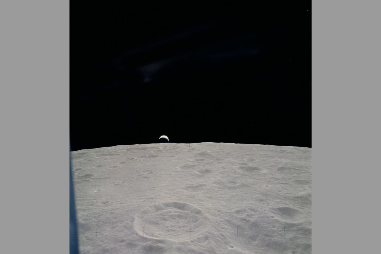 Photo by Apollo Crew The Apollo 14 crew catch a cresent view of the Earth as it raises above the lunar horizon during one moon orbit