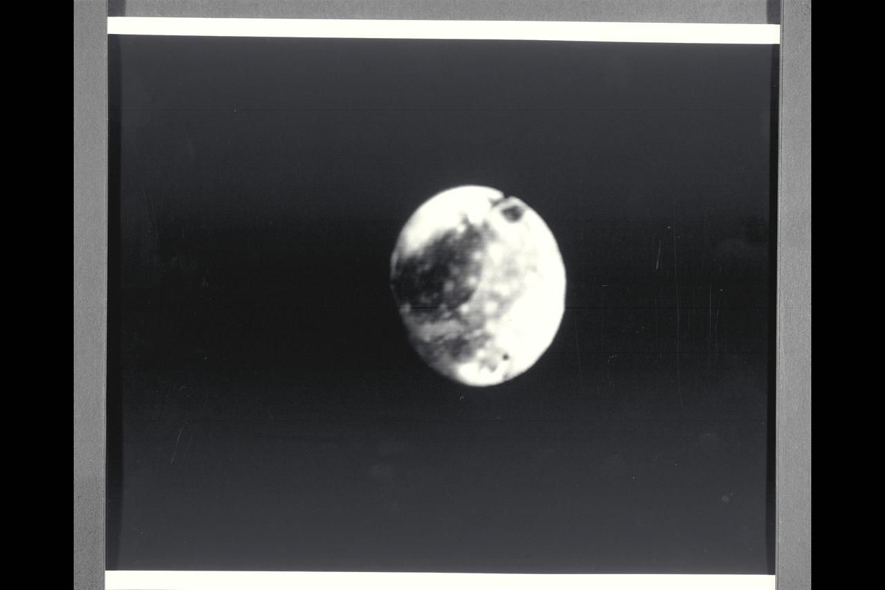 Range : 6 million kilometers (3.7 million miles) Central Longitude 120 degrees west, North is up. and 3rd from the planet. Photo taken after midnight Ganymede is slightly larger than Mercury but much less dense (twice the density of water). Its surface brightness is 4 times of Earth's Moon. Mare regions (dark features) are like the Moon's but have twice the brightness, and believed to be unlikely of rock or lava as the Moon's are. It's north pole seems covered with brighter material and may be water frost. Scattered brighter spots may be related to impact craters or source of fresh ice.