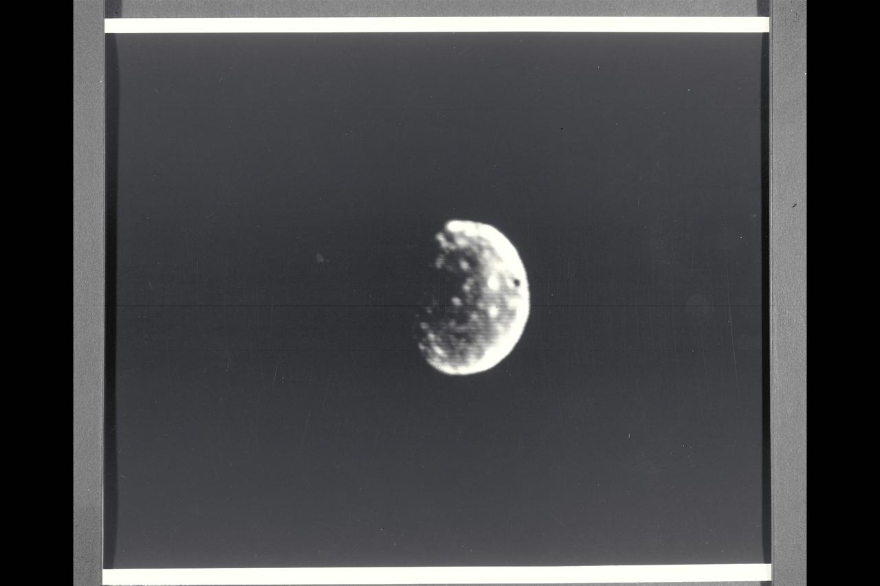 Range : 7 million kilometers (5 million miles) Callisto is Jupiter's outermost Galilean satellites and darkest of  the four(but almost twice as bright as Earth's Moon).  Mottled appearance from bright and dark patches.  Bright spots seem like rayed or bright halved craters seen on our Moon.  This face is always turned toward Jupiter.  Photo taken through violet filter.  Ganymede is slightly larger than Mercury but much less dense (twice the density of water).  Its surface brightness is 4 times of Earth's Moon.  Mare regions (dark features) are like the Moon's but have twice the brightness, and believed to be unlikely of rock or lava as the Moon's are.  It's north pole seems covered with brighter material and may be water frost.  Scattered brighter spots may be related to impact craters or source of fresh ice.