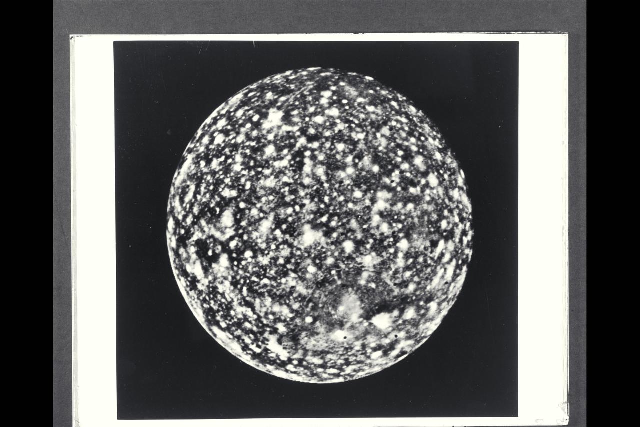 P-21745 BW Range: 1.1 million miles (675,000 miles) This image of Callisto taken by Voyager 2 was enhanced to reveal detail in the scene.  Voyager 1's high resolution coverage was of the hemisphere just over the right-hand (eastern) horizon, and the large ring structure discovered by Voyager 1 is just over the eastern limb. This image shows yet another ring structure in the upper part of the picture. Callisto exhibits some of the most ancient terrain seen on any of the satellites. Scientists think Callisto's surface is a mixture of ice and rock dating back to the final stages of planetary accretion (over 4 billion years ago) when the surface was pockmarked by a torrential bombardment of meteorites. Younger craters show as bright spots, probably because they expose fresh ice and frost.