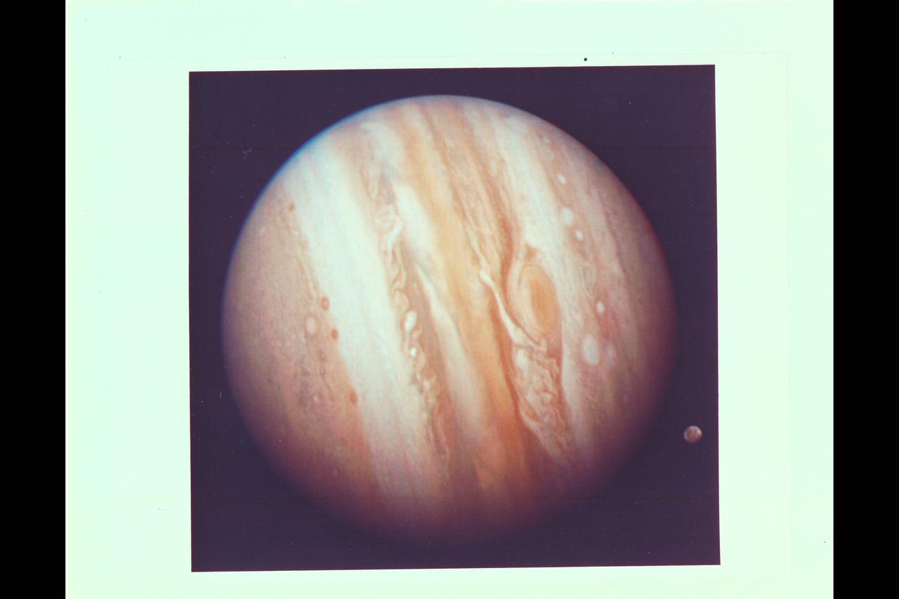 Photo by Voyager 1 (JPL) The spacecraft took this photo of the planet Jupiter on Jan 24, while still more than 25 million miles (40 million kilometers) away. As the spacecraft draws closer to the planet (about 1 million kilometers a day) more details are emergng in the turbulent clouds. The Great Red Spot shows prominently below center, surrounded by what scientists call a remarkably complex region of the giant planet's atmosphere. An elongated yellow cloud within the Great Red Spot is swirling around the spot's interior boundary in a counterclockwise direction with a period of a little less than six days, confirming the whirlpool-like circulation that astronomers have suspected from ground-based photographs. Ganymede, Jupiter's largest satellite, can be seen to the lower left of the planet. Ganymede is a planet-sized body larger than Mercury. This color photo was assembled at Jet Propulsion Laboratory's Image Processing Lab from there black and white images taken through filters. The Voyagers are managed for NASA's Office of Space Science by Jet Propulsion Laboratory.  (ref: P-20945C  Mission Image 1-9)