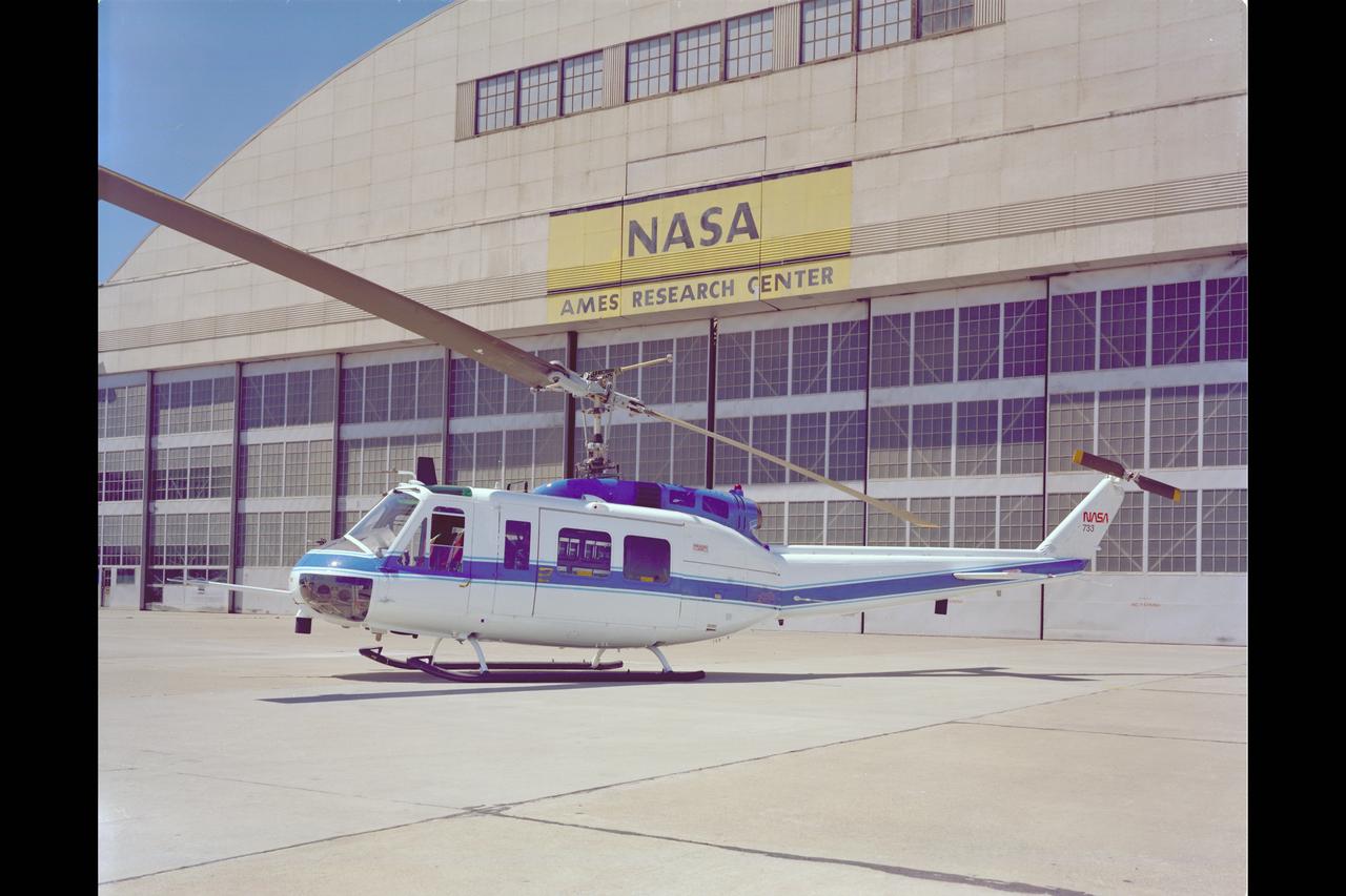 UH-IH (USA 69-15231 NASA-733) V/STOLAND helicopter  parked in front of the NASA Hangar. Note:  Used in publication in Flight Research at Ames;  57 Years of Development and Validation of Aeronautical Technology NASA SP-1998-3300 fig. 129