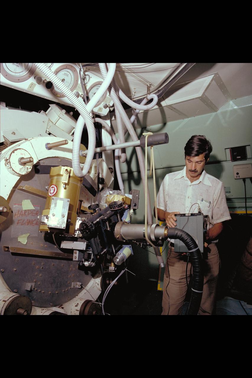 Astronomer checks out his experment package (Harper Flange) mounted to Telescope in C-141 KAO Aircraft