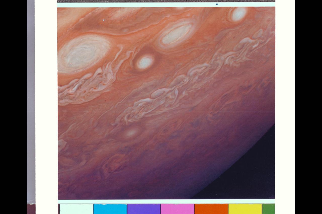 Range : 4.3 million km. ( 2.7 million miles ) This photograph taken from Voyager I, shows the area east of the Great Red Spot. The dark halo surrounding the bright spot, just to the right of the bright oval, is said by scientists to be, almost certainly, a five micron hot spot. This is a region of the atmosphere warmer than those around it. The dark halo may represent an area in which we are looking deeper into Jupiter's Atmosphere, although not yet completely understood.
