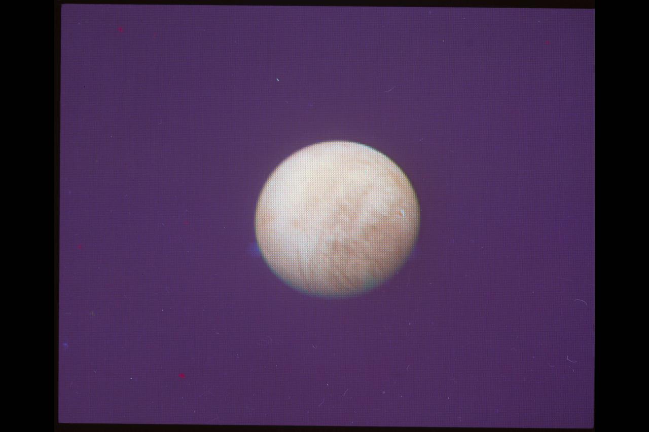 P-21744 C Range: 4.2 million kilometers (2.6 million miles) In this image of Europa acquired by Voyager 2, global scale dark streaks are becoming visible. Europa, the size of the earth's moon, is apparently covered by water ice as indicated by ground based spectrometers and its brightness. The central longitude of this view is 235Â° west. Bright rayed impact craters which are abundant on ancient Ganymede and Callisto would easily be visible at this range. The suggestion is that Europa's surface is young and that the streaks are reflections of currently active internal dynamic processes.