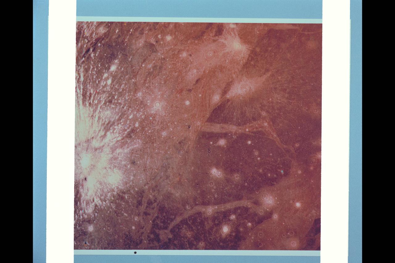 P-21762 C This color picture of Ganymede in the region 30Â° S 180Â° W shows features as small as 6 kilometers (3.7 miles) across. Shown is a bright halo impact crater that shows the fresh material thrown out of the crater. In the background is bright grooved terrain that may be the result of shearing of the surface materials along fault planes. The dark background material is the ancient heavily cratered terrain--the oldest material preserved on the Ganymede surface.