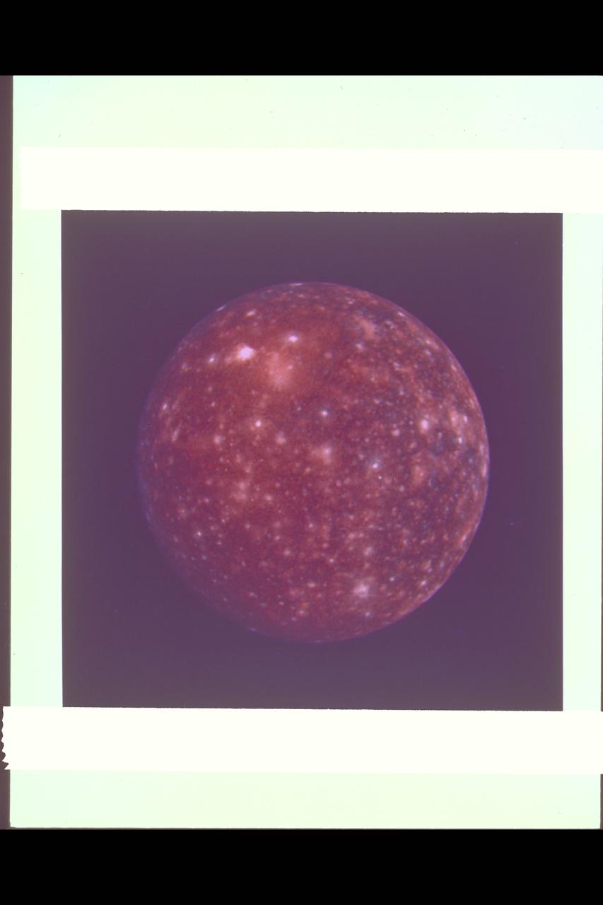 Range :  1,094,666 km (677,000 mi.) This false color picture of Callisto was taken by Voyager 2 and is centered on 11 degrees N and 171 degrees W.  This rendition uses an ultraviolet image for the blue component.  Because the surface displays regional contrast in UV, variations in surface materials are apparent.  Notice in particular the dark blue haloes which surround bright craters in the eastern hemisphere.  The surface of Callisto is the most heavily cratered of the Galilean satellites and resembles ancient heavily cratered terrains on the moon, Mercury and Mars.  The bright areas are ejecta thrown out by relatively young impact craters.  A large ringed structure, probably an impact basin, is shown in the upper left part of the picture.  The color version of this picture was constructed by compositing black and white images taken through the ultraviolet, clear and orange filters.