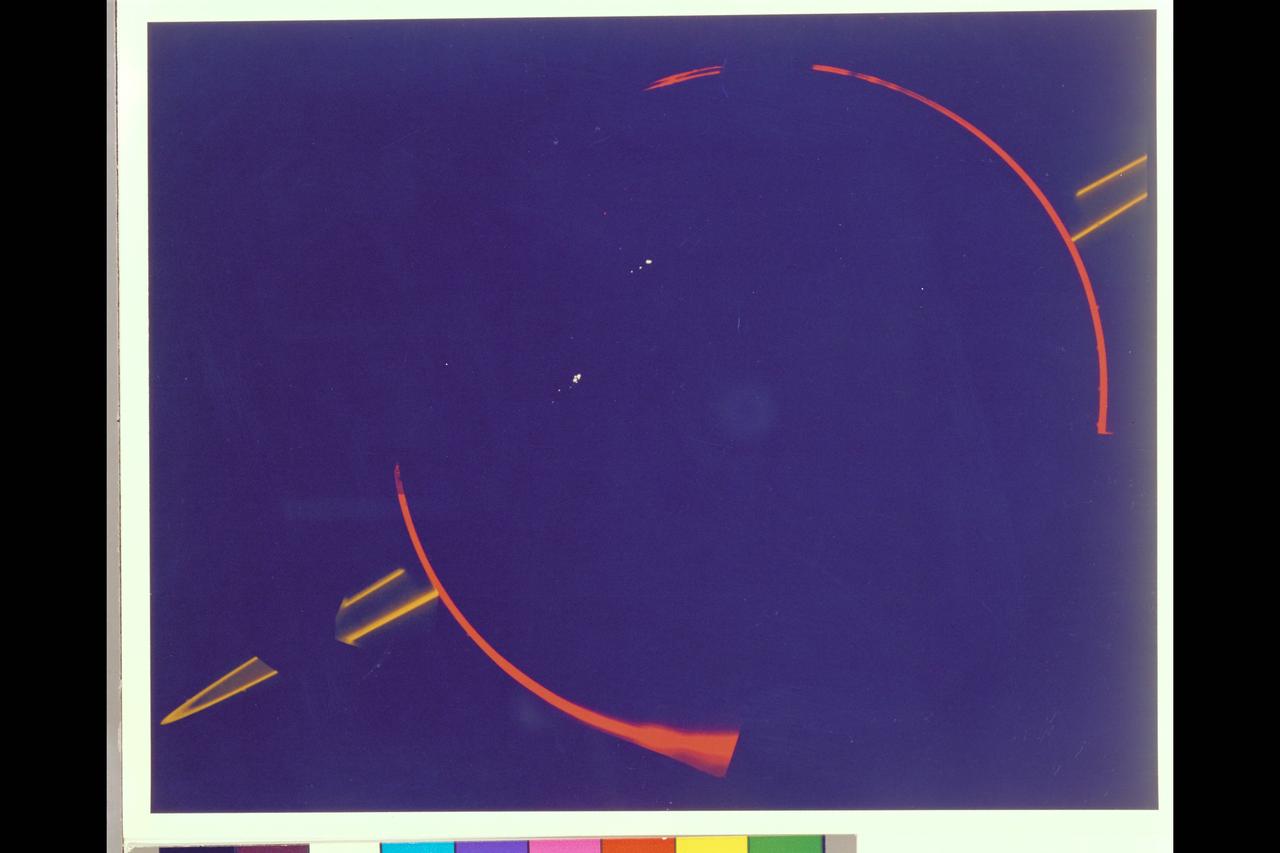 JUPITER'S FAINT RING SYSTEM IS SHOWN HERE AS TWO ORANGE LINES PROTRUDE FROM THE LEFT TOWARD JUPITER'S LIMB.  THIS COLORFUL COMPOSITE WAS TAKEN IN JUPITER'S SHADOW THROUGH ORANGE AND VIOLET FILTERS. THE COLORFUL IMAGES OF JUPITER'S LIMB ARE EVIDENCE OF THE SPACECRAFT MOTION DERING THIS LONG EXPOSURE.  VOYAGER 2
