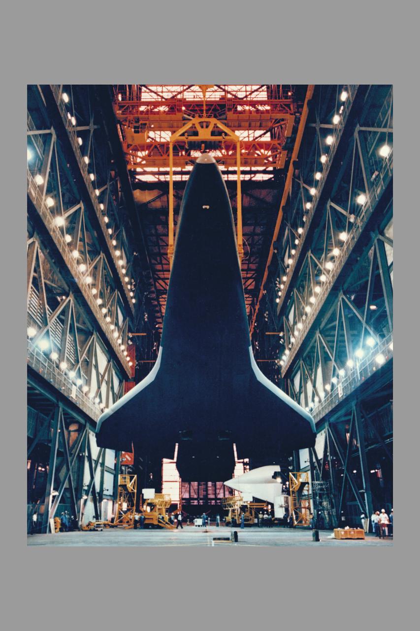 Space Shuttle Orbiter Enterprise is lowered to the floor of the transfer aisle in the Vehicle Assembly Building during destacking operations.  The Enterprise, mated to an external tank and twin inert solid rocket boosters, formed a nonlaunchable Space Shuttle which was used for fit and function checks of assembly, test and launch facilities at the nation's Spaceport.  Enterprise will be tansported to the Shuttle Landing Facility, mounted piggyback on its 747 Shuttle Carrier Aircraft, and flown to NASA's Dryden Flight Research Center, California.