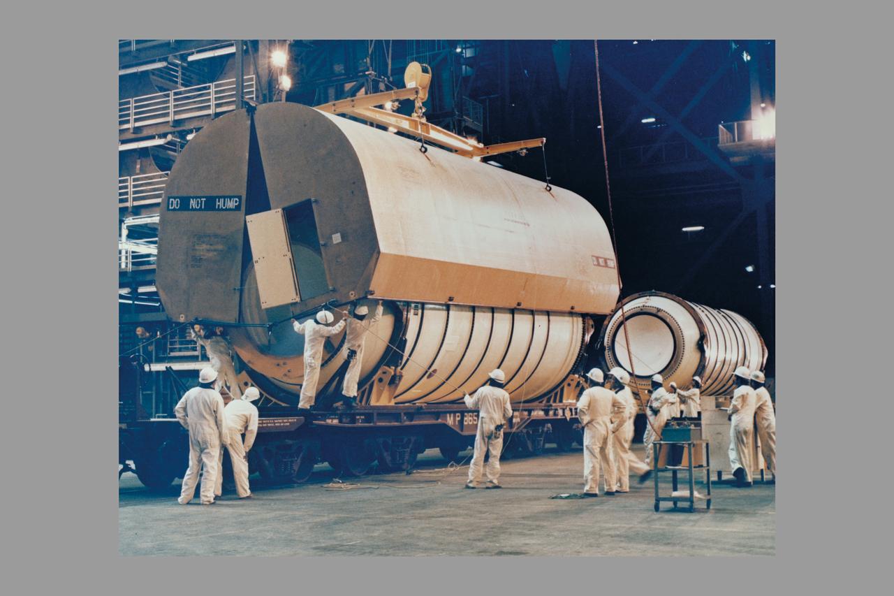 The first solid rocket booster solid motor segemnts to arrive at KSC, the left and right hand aft segments are off-loaded into High Bay 4 in the Vehicle Assembly Building and mated to their respective SRB aft skirts. The two aft assemblies will support the entire 150 foot tall solid boosters, in turn supporting the external tank and Orbiter Columbia on the Mobile Launcher Platform, for the first orbital flight test of the Space Shuttle.