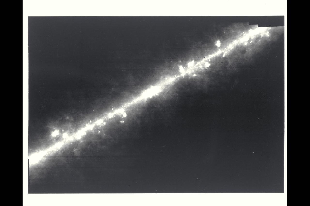 Milky way - This image of the center of our galaxy was produced from observtons made by the Infrared Astronomical Satellite (IRAS). The infrared telescope carried by IRAS sees through the dust and gas that obscures stars and other objects when viewed by optical telescopes. The bulge in the band is the center of the galaxy. The knots and blobs scattered along the band are giant clouds of interstellar gas and dust heated by nearby stars. Some are wrmed by newly formed stars in the surrounding cloud and some are heated by nearby massive, hot, blue stars tens of thousands of times brighter than our Sun.