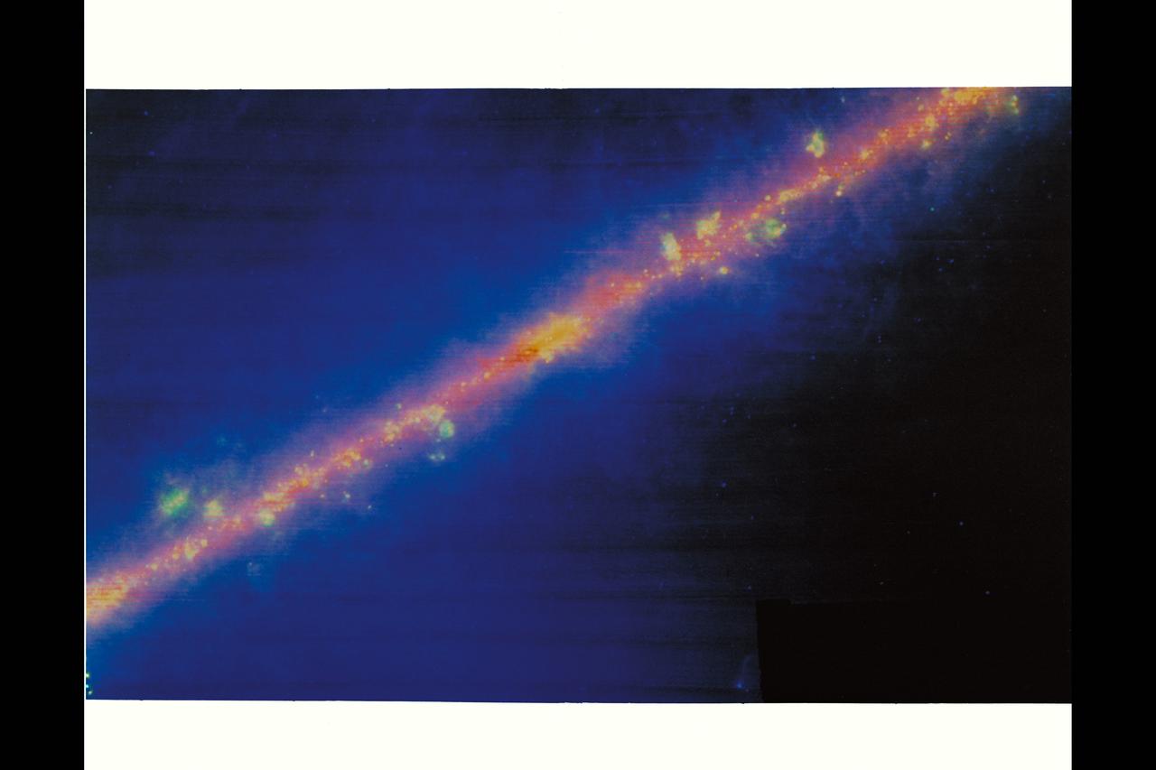 Milky way - The real shape of our galaxy is revealed in this infrared image obtained by IRAS. Infrared light penetrates the dust clouds and shows that the galaxy appears as a thin disk, just like the edge-on spiral galaxies we see throughtout the cosmos. The bulge in the band is the center of the galaxy. The yellow and green knots and blobs scattered along the band are giant clouds of interstellar gas and dust heated by nearby stars.