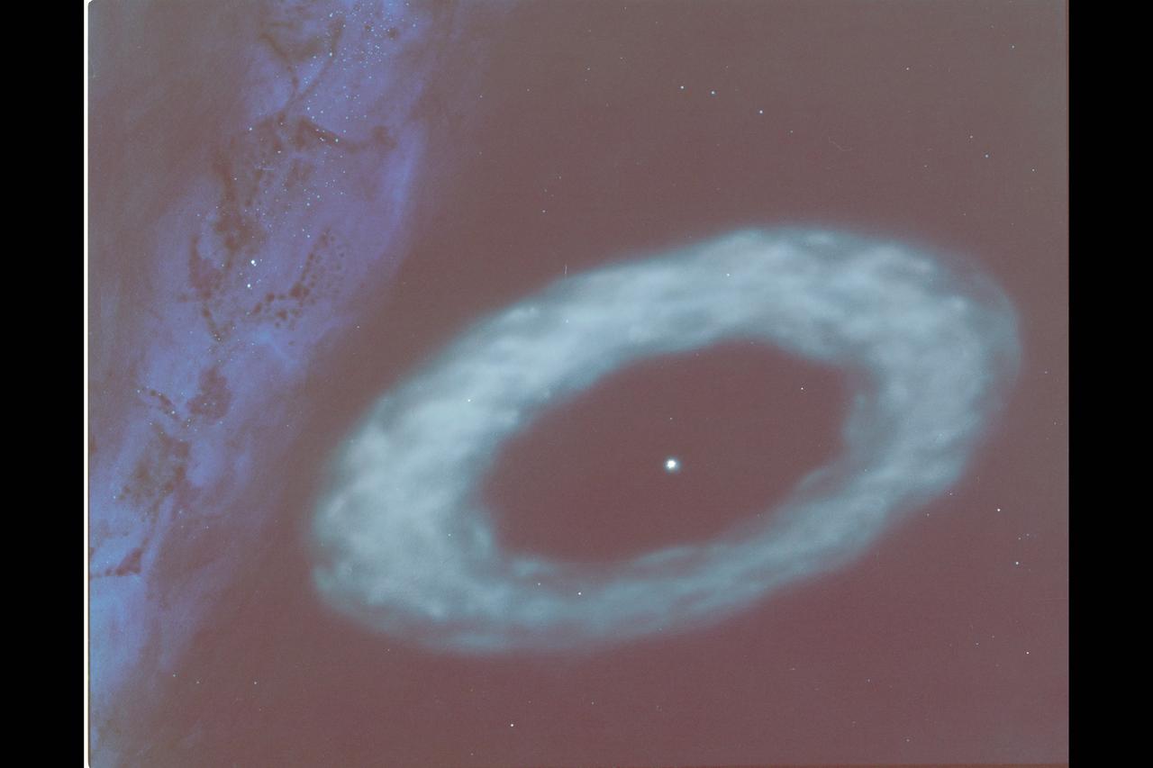 This artist's concept illustrates the ring of material discovered by the Infrared Astronomical Satellite around the star Vega. IRAS scientists believe the material probably consists of dust and small objects resembling meteors. As depicted here, the ring of particles is thin enough toallow light from distant stars to shine through. The plane of the Milky Way is to the right.