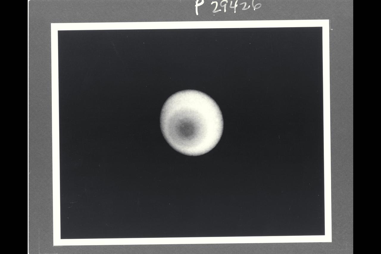 Range :  36 million km. ( 22 million miles ) P-29426B/W This Voyager 2 photograph of Uranus shows the is the  first picture to show clear evidence of latitudinal banding in the planet's atmosphere.  This is a computerized summation of five images shot by the narrow angle camera. The concentric pattern emanates like a bulls-eye from the planets pole of rotation, which, in this view, lies left of center. uranus lies almost on its side with respect to the other planets  and is rotating in a counter clockwise direction, as seen here. Clouds in the Uranian atmosphere give rise to the pattern, the first clear evidence of banding similiar to that seen previosly on Saturn and Jupiter. The bandind on Uranus, however, shows much less contrast. At the distance at which the images were acquired, Voyager's camera could have detected individual features as small as 660 km. (410 miles) across, but no such cloud or markings  were apparent. Scientists cannot yet say what properties, such as cloud height, composition, or particle size, are giving rise to the varying levels of brightness visible here. The images composing this picture  were shot through a filter that transmits only violet light. in the original, unprocessed images, the contrast of features  producing the banding is low, not more than 10 percent. In order to reduce 'noise' and enhance the visiblity of the features, processors  combined five images  and then compared the resulting  composite to a hypothetical featureless planet illuminated  by the Sun from  the proper direction. Only the ratio between the original data and the hypothetical image is shown.