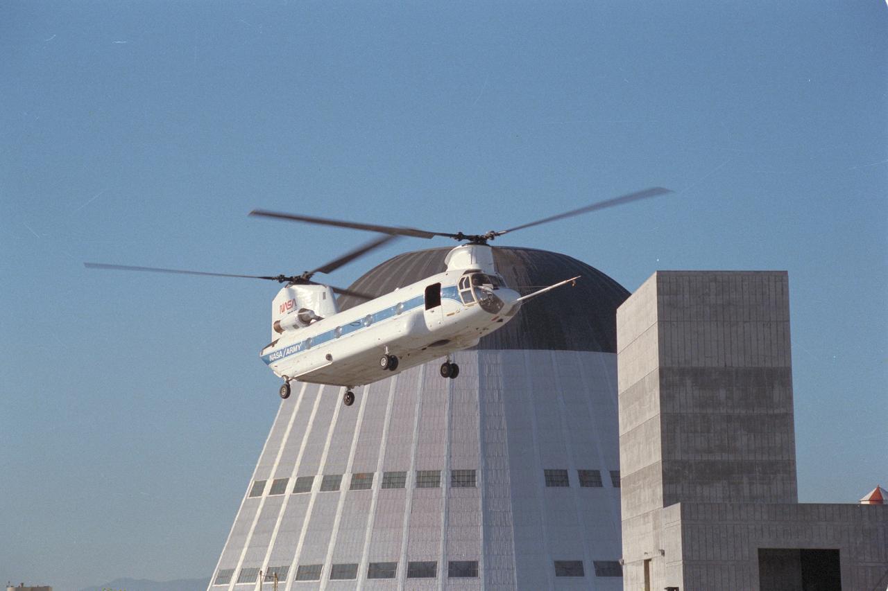 Boeing CH-47B (USA 66-19138 NASA-737) Chinook in-flight simulator with Moffet Field Navy Hangar and Ames VMS in background. Note: Used in publication in Flight Research at Ames; 57 Years of Development and Validation of Aeronautical Technology NASA SP-1998-3300 fig. 133