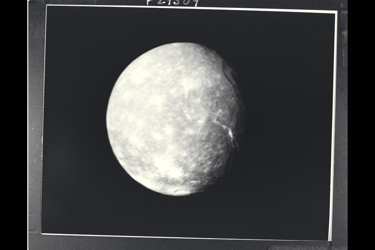 P-29509 BW Range: 500,000 kilometers (300,000 miles) This high-resolution image of Titania was made as Voyager 2 neared its closest approach to Uranus. Voyager's narrow-angle camera acquired this image through the violet and clear filters and shows details about 9 km (6 mi) in size. Titania has a diameter of about 1,600 km (1,000 MI). In addition to many scars due to impacts, Titania displays evidence of other geologic activity at some point in its history. The large trench-like feature near the terminator (day-night boundary) at middle right suggests at least one episode of tectonic activity, Another, basinlike structure near the upper right is evidence of an ancient period of heavy impact activity. The neutral gray color of Titania is characteristic of the Uranian satellites as a whole.