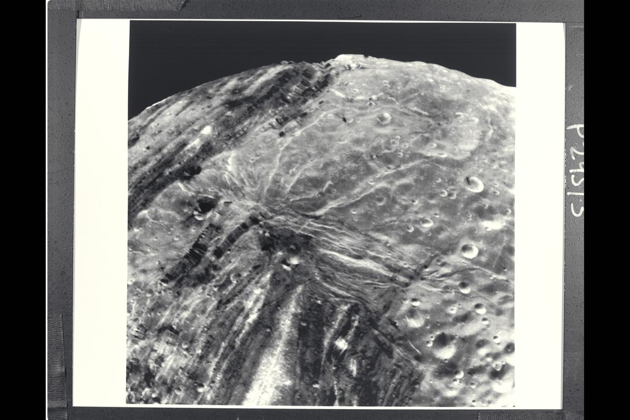 P-29513 BW Range: 31,000 kilometers (19,000 miles) This Voyager 2 image of Miranda was taken shortly before the spacecraft's closet approach to the Uranian moon.The high resolution of 600 meters (2,000 feet) reveals a bewildering variety of fractures, grooves and craters, as well as features of different albedos (reflectances). This clear-filter, narrow-angle view encompasses areas of older, heavily cratered terrain with a wide variety of forms. The grooves and troughs reach depths of a few kilometers and expose materials of different albedos. The great variety of directions of fracture and troughs, and the different densities of impact craters on them, signify a long, complex geologic evolution of this satellite.