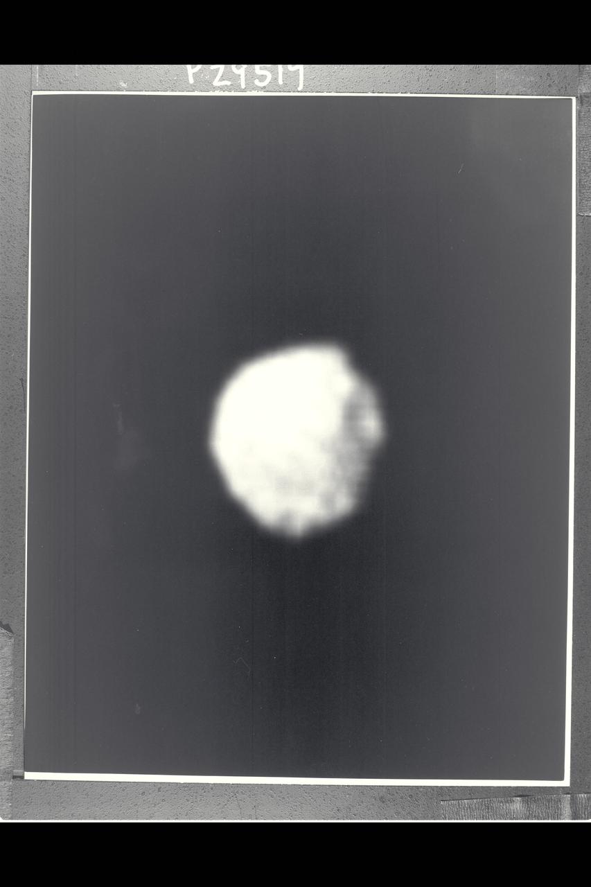 P-29519BW Range: 500,000 kilometers (300,000 miles) Several craters are seen on the surface of 1986U1, one of the several small moons of Uranus discovered by Voyager 2. This single image, a clear-filtered, narrow-angle picture with a resolution of about 10 km (6 mi), is the only closeup the spacecraft obtained of any of the new moons. The moon was found December 30, 1985; it was the first and largest of nine satellites discovered by the spacecraft's cameras. This image shows 1986U1 to be a dark, nearly spherical object, with a diameter of about 150 km (90 mi); the dark surface reflects only 7 percent of the incident light. The picture was inserted into the Voyager encounter sequence late in its development.This image has had a complex history, having been recorded on the spacecraft tape recorder and first played back during the late afternoon of its recording. An antenna-pointing problem at one of the Austrailian tracking stations led to the loss of the data, so the image had to be retransmitted.