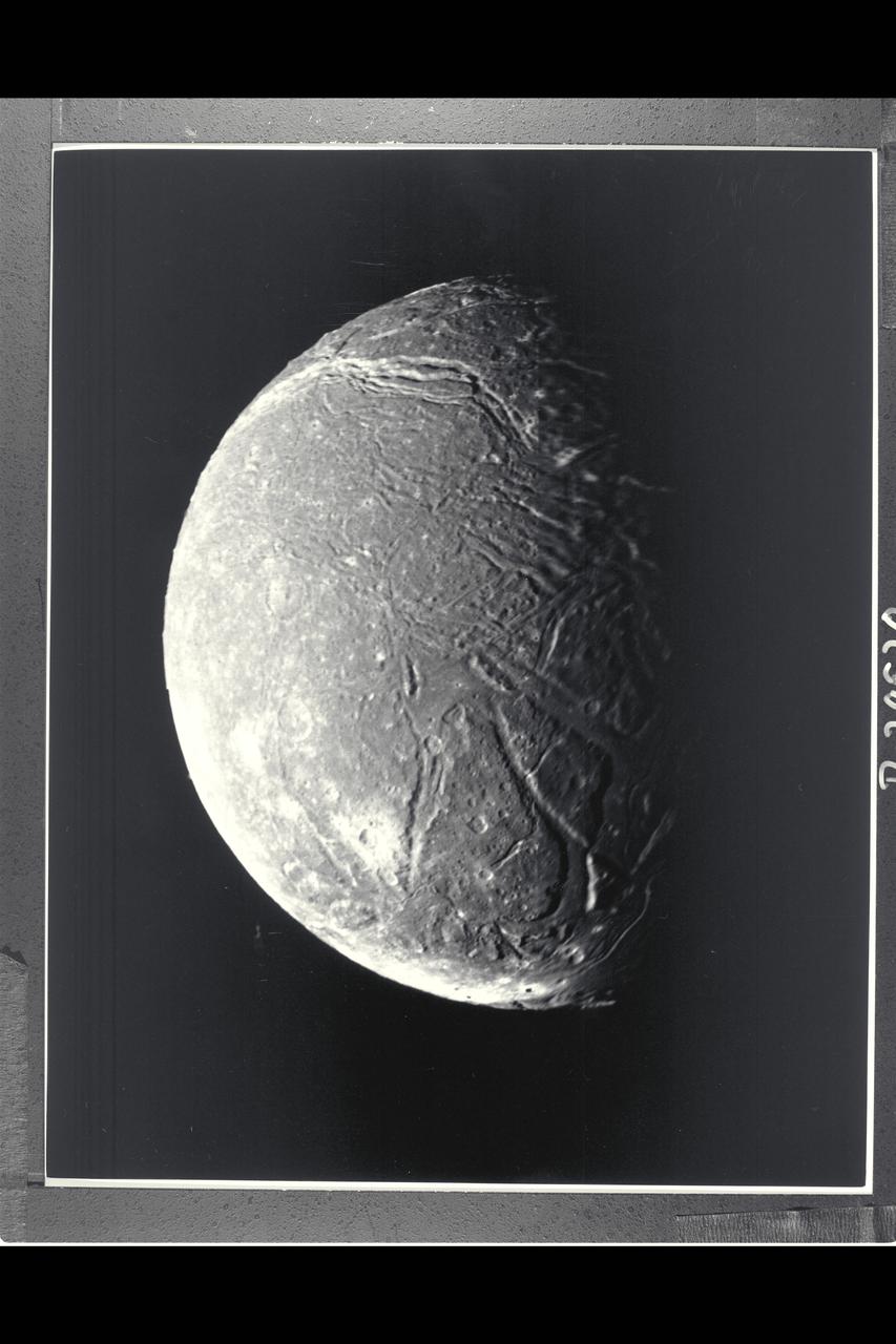 P-29520 BW Range: 130,000 kilometers (80,000 miles) This mosaic, taken through the clear-filter, narrow-angle camera, of the four highest-resolution images of Ariel represents the most detailed Voyager 2 picture of this satellite of Uranus. Ariel is about 1,200 km (750 mi) in diameter; the resolution here is 2.4 km (1.5 mi). Much of Ariel's surface is densely pitted with craters 5 to 10 km (3 to 6 mi) across. These craters are close to the threshold of detection in this picture. Numerous valleys and fault scarps crisscross the highly pitted terrain. voyager scientists believe the valleys have formed over down-dropped fault blocks (graben); apparently, extensive faulting has occured as a result of expansion and stretching of Ariel's crust. The largest fault valleys, near the terminator at right, as well as a smooth region near the center of this image, have been partly filled with deposits that are younger and less heavily cratered than the pitted terrain. Narrow, somewhat sinuous scarps and valleys have been formed, in turn, in these young deposits. It is not yet clear whether these sinuous features have been formed by faulting or by the flow of fluids.