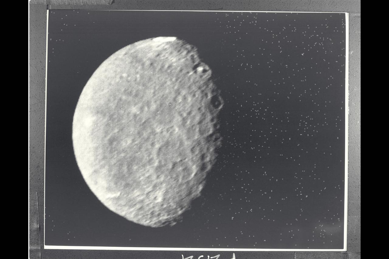 P-29521 BW Range: 557,000 kilometers ( 346, 000 miles) The southern hemisphere of Umbriel displays heavy cratering in this Voyager 2 image. This frame, taken through the clear-filter of Voyager's narrow-angle camera, is the most detailed image of Umbriel, with a resolution of about 10 km (6 mi). Umbriel is the darkest of Uranus' larger moons and the one that appears to have experienced the lowest level of geological activity. It has a diameter of about 1,200 km (750 mi) and reflects only 16 percent of the light striking its surface; in the latter respect, Umbriel is similiar to lunar highland areas. Umbriel is heavily cratered but lacks the numerous bright-ray craters seen on the other large Uranian satellites; this results in a relatively uniform surface albedo (reflectivity). The prominent crater on the terminator (upper right) is about 110 km (70 mi) across and has a bright central peak. The strangest feature in this image (at top) is a curious bright ring, the most reflective area seen on Umbriel. The ring is about 140 km (90 mi) in diameter and lies near the satellite's equator. The nature of the ring is not known, although it might be a frost deposit, perhaps associated with an impact crater. Spots against the black background are due to 'noise' in the data.