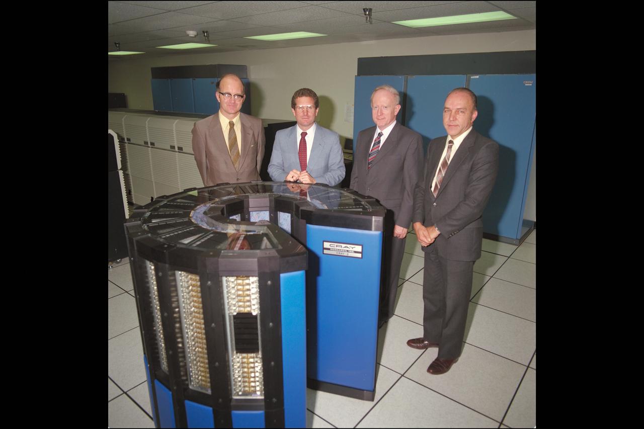 Ames Director William 'Bill' Ballhaus (center left) joins visitor Sir Jeffrey Pope from Royla Aircraft Industry, England (center right) at the NAS Facility Cray 2 computer with Ron Deiss, NAS Deputy Manager (L) and Vic Peterson, Ames Deputy Director (R).