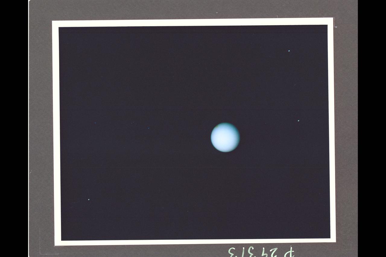 Range :  74 million km. ( 46 million miles ) P-29313CThis Voyager photograph of Uranus is a composite of for images taken by the narrow angle camera. At this range, clouds and other features in the atmosphere as small as 1,370 km. could be detected by Voyager 2. Yet, no such features are visible.  This view is toward the illuminated south pole of Uranus. The predominant blue color is the result of atmospheric methane, which absorbs the red wavelengths  from incoming sunlight. The spot at the upper left edge of the planet's disk reulted from the removal of a reseau mark used in making measurments on the photograph. Three of Uranus' five known satellites are visible; Miranda ( at far right, closest to the planet ), Ariel ( next out , at top), and Umbriel ( lower left ). Titania and Oberon are now outside the narrow angle camera's field of view when it centered on the planet. This color composite was made from images taken through blue, green, orange, and clear filters.
