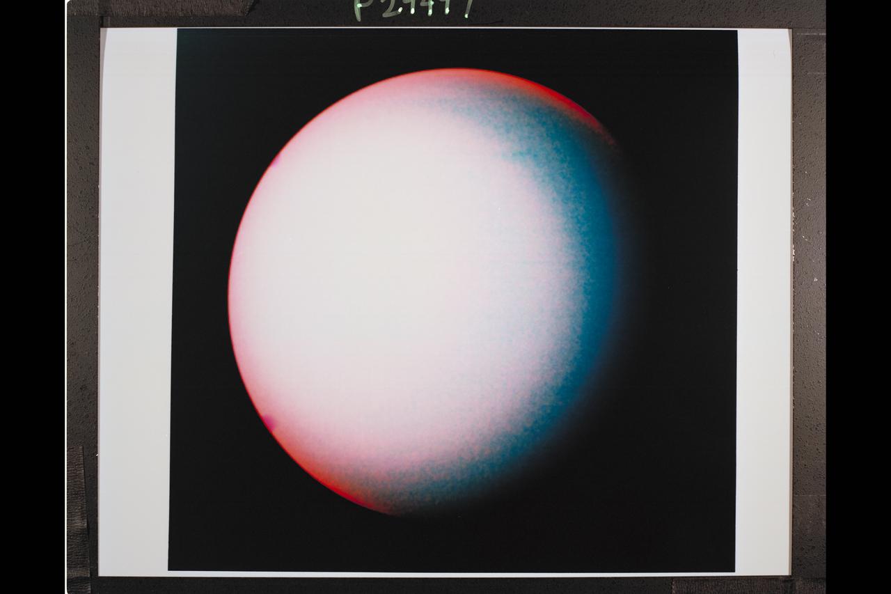 Range : 2.7 million miles (1.7 million miles) P-29497C Tis Voyager 2, false color composite of Uranus demonstrates the usefulness of special filters in the Voyager cameras for revealing the presence of high altitude hazes in Uranus' atmosphere. The picture is a composite of images obtained through the single orange and two methane filters of Voyager's wide angle camera. Orange, short wavelength and long wavelength methane images are displayed, retrospectively, as blue, green, and orange. The pink area centered on the pole is due to the presence of hazes high in the atmosphere that reflect the light before it has traversed a long enough path through the atmosphere to suffer absorbtion by methane gas. The bluest region at mid-latitude represent the most haze free regions on Uranus, thus, deeper cloud levels can be detected in these areas.