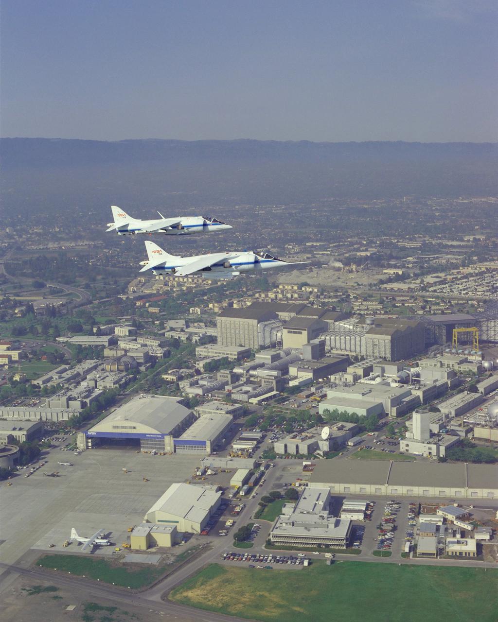 AV-8B (NASA-719) and AV-8C (NASA-704) air to air formation flight with T-38, U-2 (NASA-708) with pilots G. Hardy and J. Martin over NASA Ames Research Center, Moffett Field.