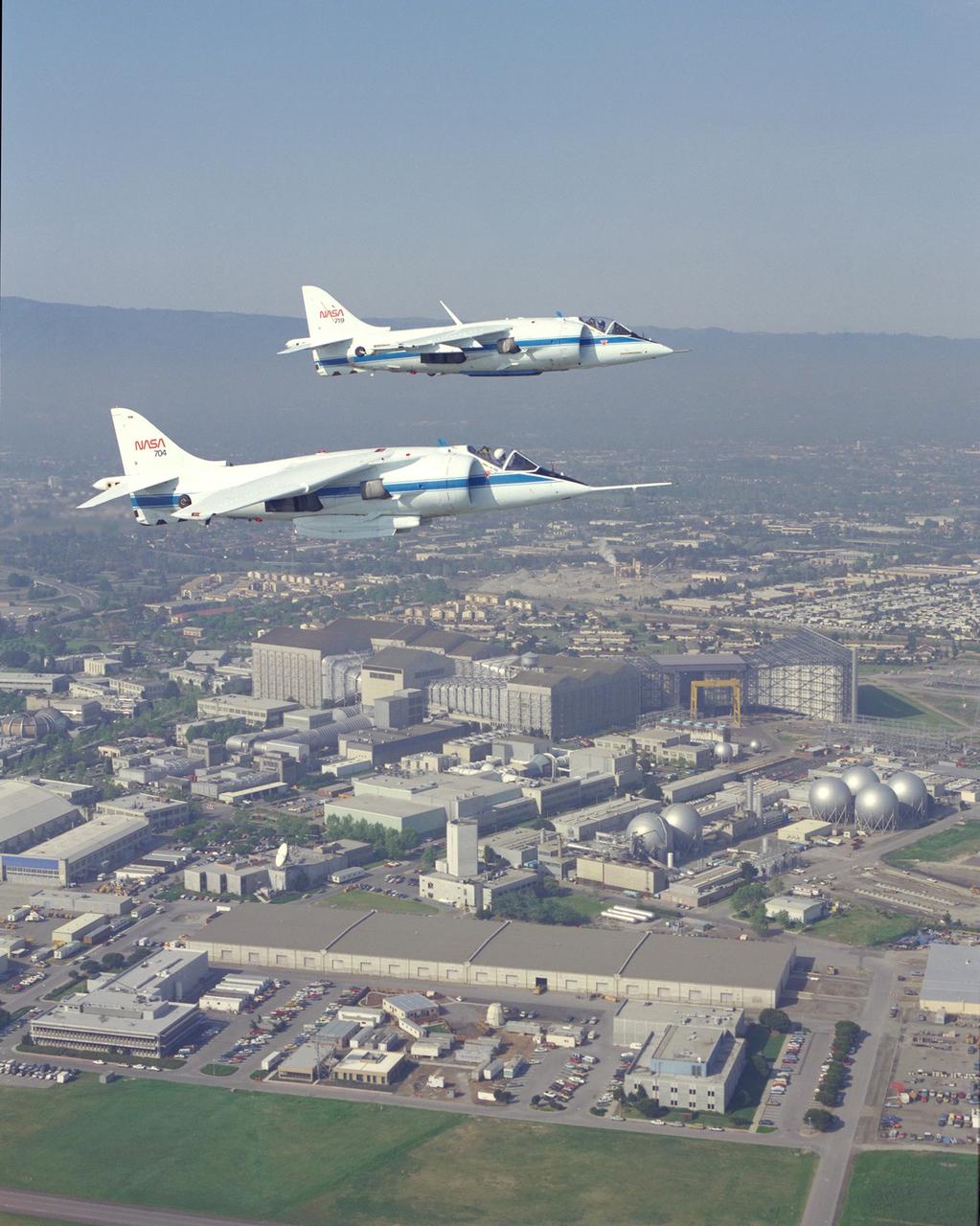 AV-8B (NASA-719) and AV-8C (NASA-704) air to air formation flight  over NASA Ames Research Center, Moffett Field.